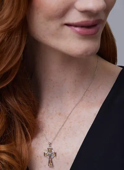 Close up shot of red haired model wearing Silver Celtic Trinity Diamond And Emerald Cross Pendant